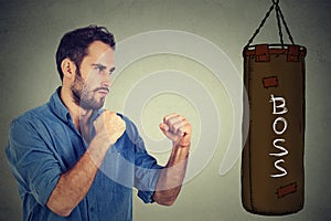 Man ready to punch boxing bag with boss written on it. Employee employer relationship concept