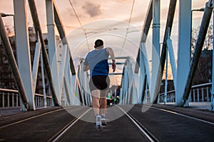 Man rear view running fast along bridge