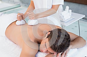 Man receiving back massage at spa center