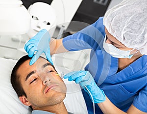 Man receiving carboxytherapy procedure at beauty clinic