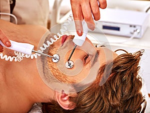 Man receiving electric facial peeling hydradermie massage. photo