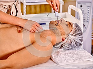 Man receiving electric facial peeling hydradermie photo