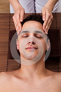 Man Receiving Head Massage From Massager In Spa