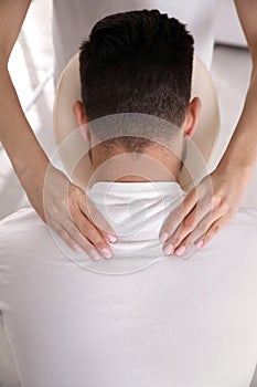 Man receiving massage in modern chair indoors, closeup