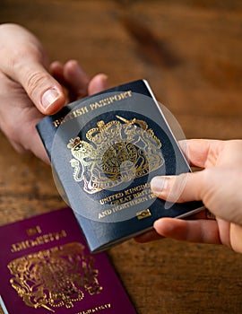 man recieving new post Brexit blue British passport with old European Union red one the table Devon, United Kingdom