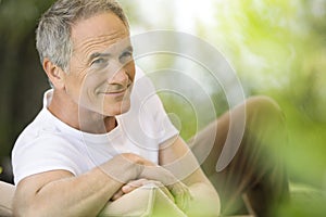 Man Reclining On Deck Chair In Garden