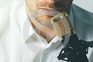 man recording podcast. speaking in microphone closeup