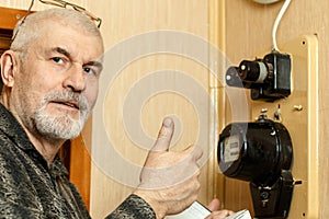 A man records the readings of an electricity meter