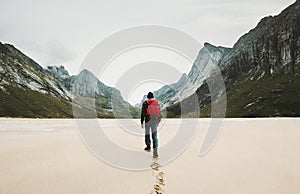 Man with red backpack walking alone photo