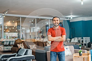 man in red with crossed hands in furniture store department