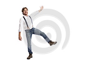 A man with red hair in a white shirt and jeans is jumping. Isolated on white background. Space for text. Baner