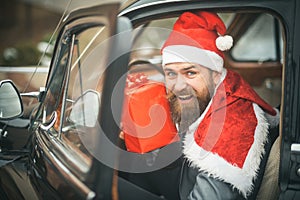 Man in red hat deliver xmas gifts in retro car