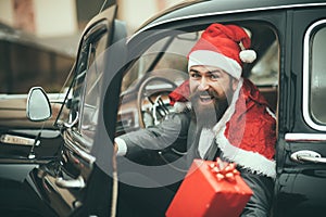 Man in red hat deliver xmas gifts in retro car