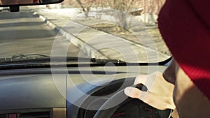 Man in a red hat driving on an empty road. Shooting close up from the back of the car