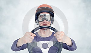 Man in red helmet and goggles with steering wheel. car driver concept