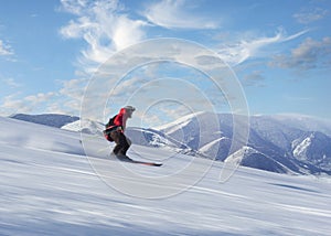 Man in red jacket skiing down slope in bright sunshine