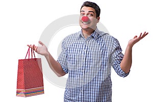 Man with a red nose funny holding a shopping bag gift present is