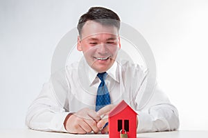 Man with a red paper house