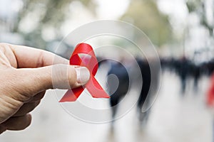 Man with a red ribbon for the fight against AIDS