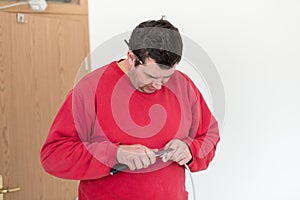 Man in red shirt stripping wire photo