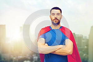 Man in red superhero cape over city background
