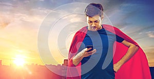 Man in red superhero cape using smartphone