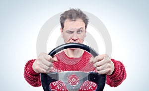 Man in red sweater driving a car with a steering wheel, drive concept