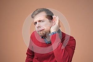 Man in red sweater trying to listen to latest gossip.