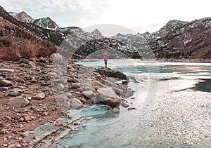 A man with a red umbrella on the lake in the Sierras