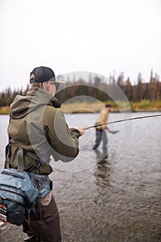 Man reeling in fish in alaska