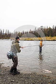 Man reeling in fish in alaska