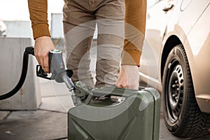 Man refilling canister with fuel on the petrol station. Close up view. Gasoline, diesel is getting more expensive.