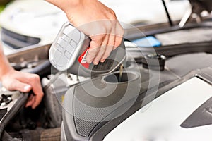 Man is refilling oil in his car