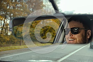 man reflection in car rear mirror