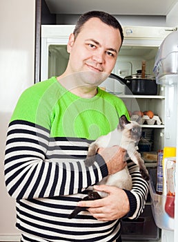 Man at refrigerator with kitten