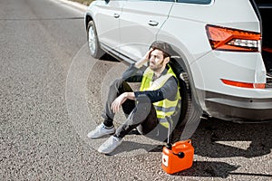 Man with refuel canister near the car on the roadside