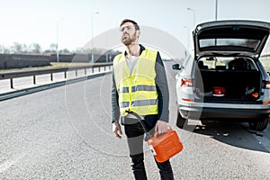 Man with refuel canister on the roadside