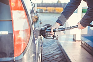 Man refueling a car during low fuel rates, fuel prices, transport concept