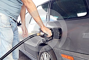 A man refueling car tank with benzin. Car service concept