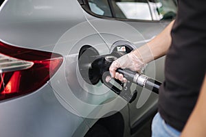 Man is refueling at gas station. Male hand filling benzine gasoline fuel in car using a fuel nozzle. Petrol prices