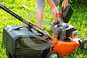 Man refueling the lawnmower on his huge garden, gardening concept