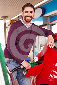 Man refuelling a car at a petrol station