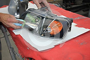 Man refurbishing car headlight