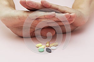 Man refuses pills, pills on the table, health, medicine, pink background