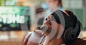 Man, relax and hypnosis with headphones for sound frequency, noise or comfort on living room sofa at home. Calm male