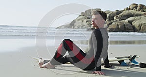 Man, relax and portrait on the beach with surfboard in summer, holiday or vacation on island. Ocean, waves and surfer