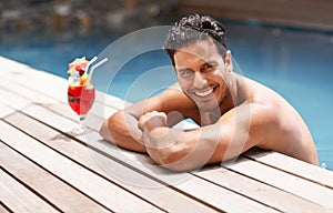 Man, relax and portrait at swimming pool with cocktail at hotel, resort and travel on luxury vacation. Summer, holiday