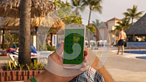 Man relax on sunbath in swimming pool with using mobile phone