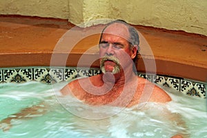 Man relaxes in jacuzzi spa