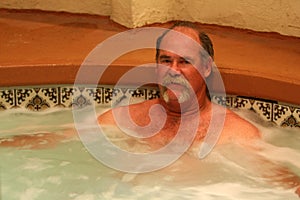 Man relaxes in jacuzzi spa